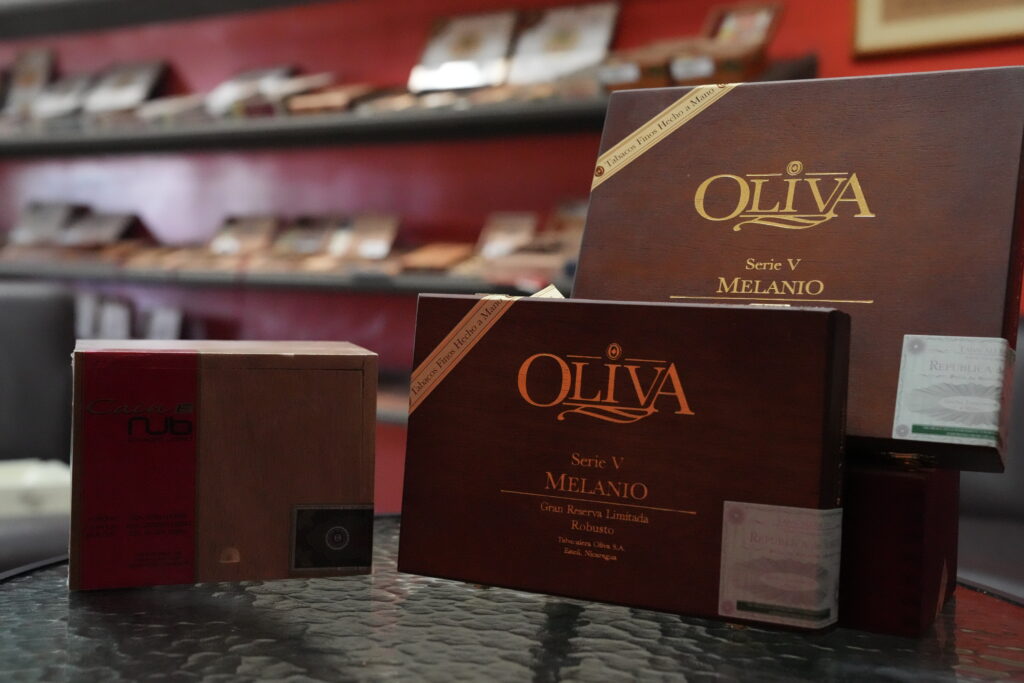 Close-up of hand-rolled cigars from Saga Bay Cigars with a sleek cigar cutter on a table.